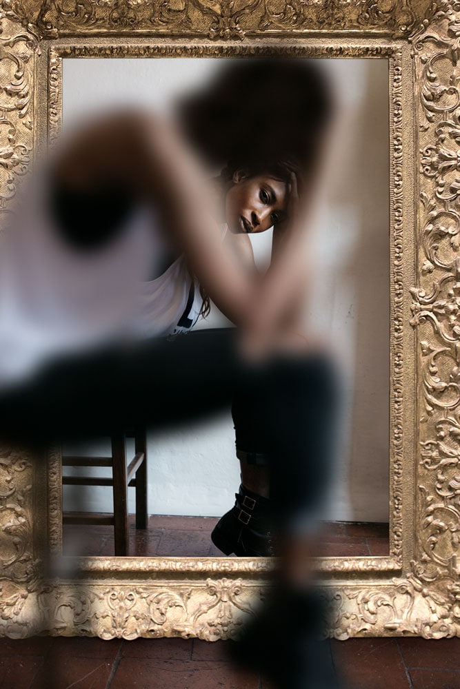 woman sitting in front of mirror